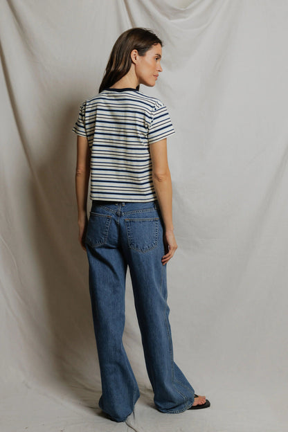 Woman shown from the back wearing a Dawn Jersey Ringer striped shirt in Navy Pacific Stripe and baggy blue jeans against a plain background