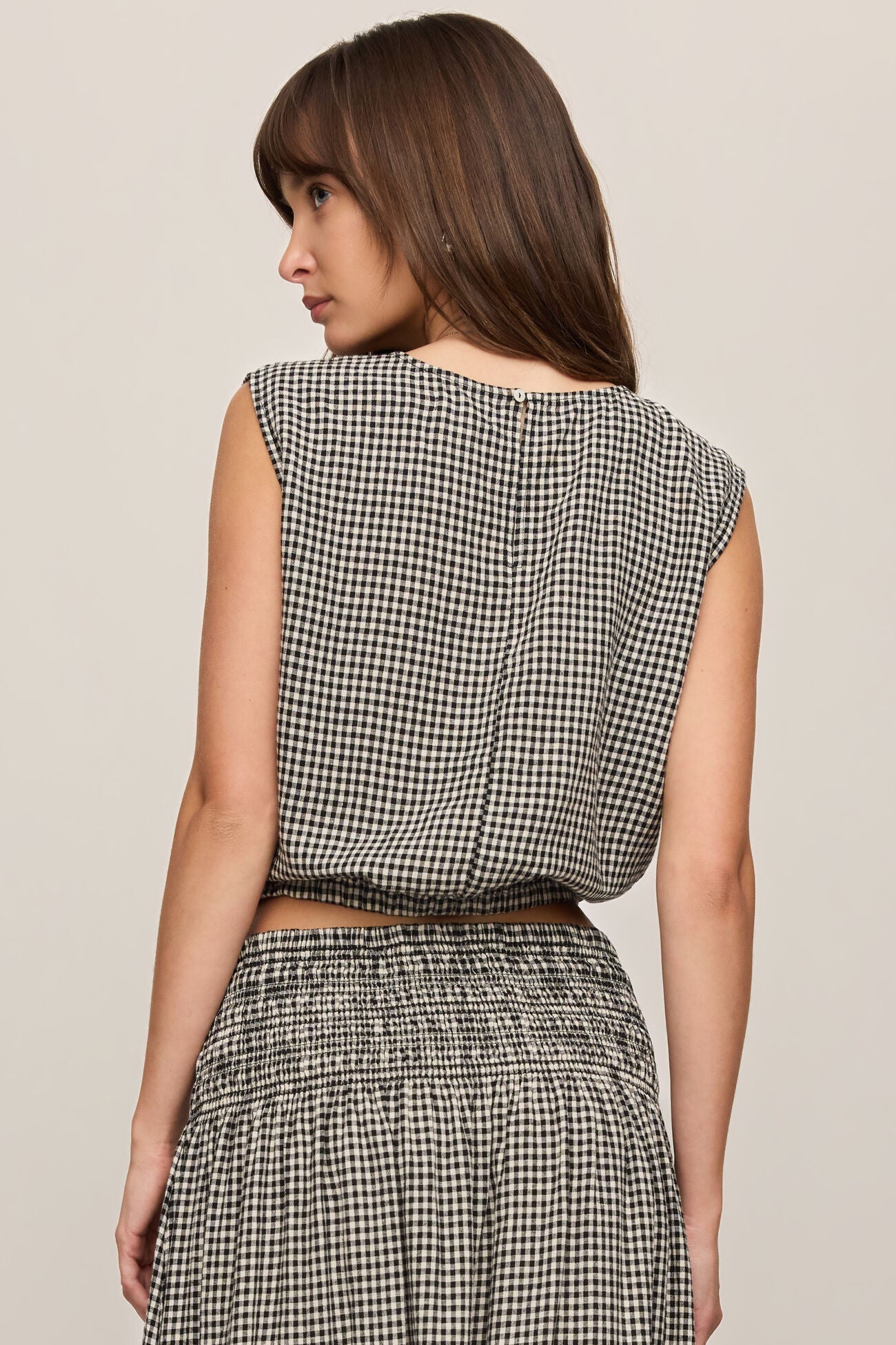 Back view of woman wearing Merit Gingham top in black & white with matching skirt 