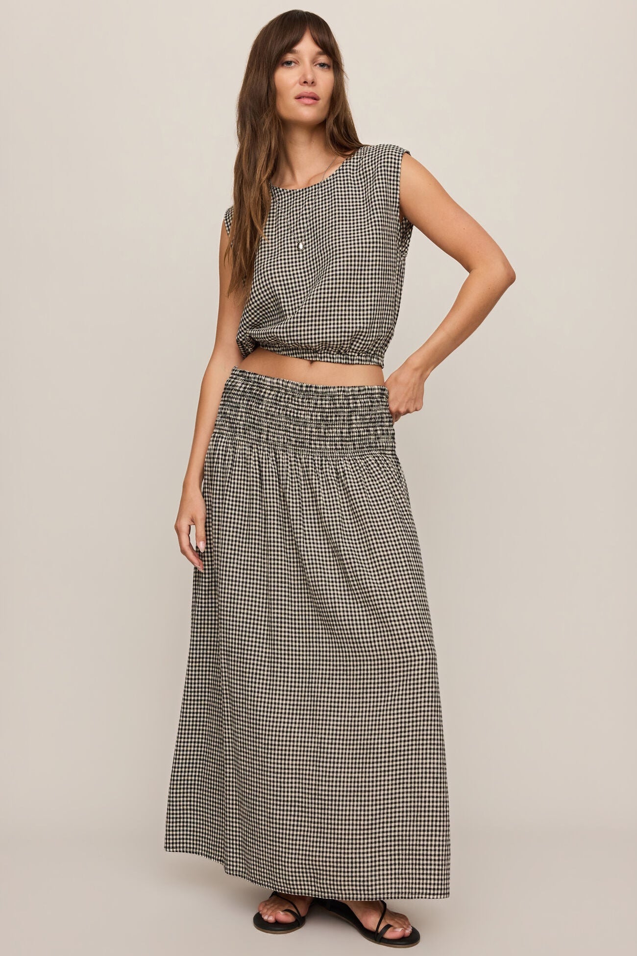 Front view of woman wearing Merit Gingham top in black & white with matching skirt 