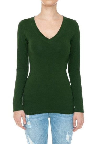 A woman wearing a dark green 'malachite' long-sleeve V-neck knit top with light blue distressed jeans, shown against a plain white background.