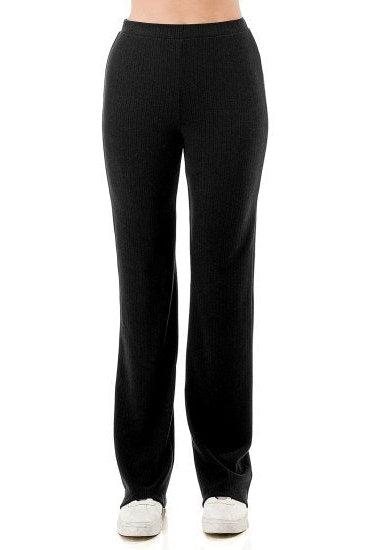 Black ribbed knit lounge pants shown on a model from the waist down, paired with white sneakers against a plain white background.