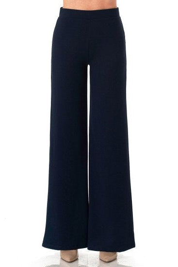 A pair of dark navy eclipse blue wide-leg trousers shown on a model from the waist down, against a plain white background.