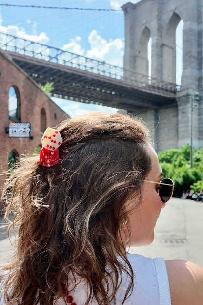 Woman with a dice hair clip in front of the Brooklyn Bridge