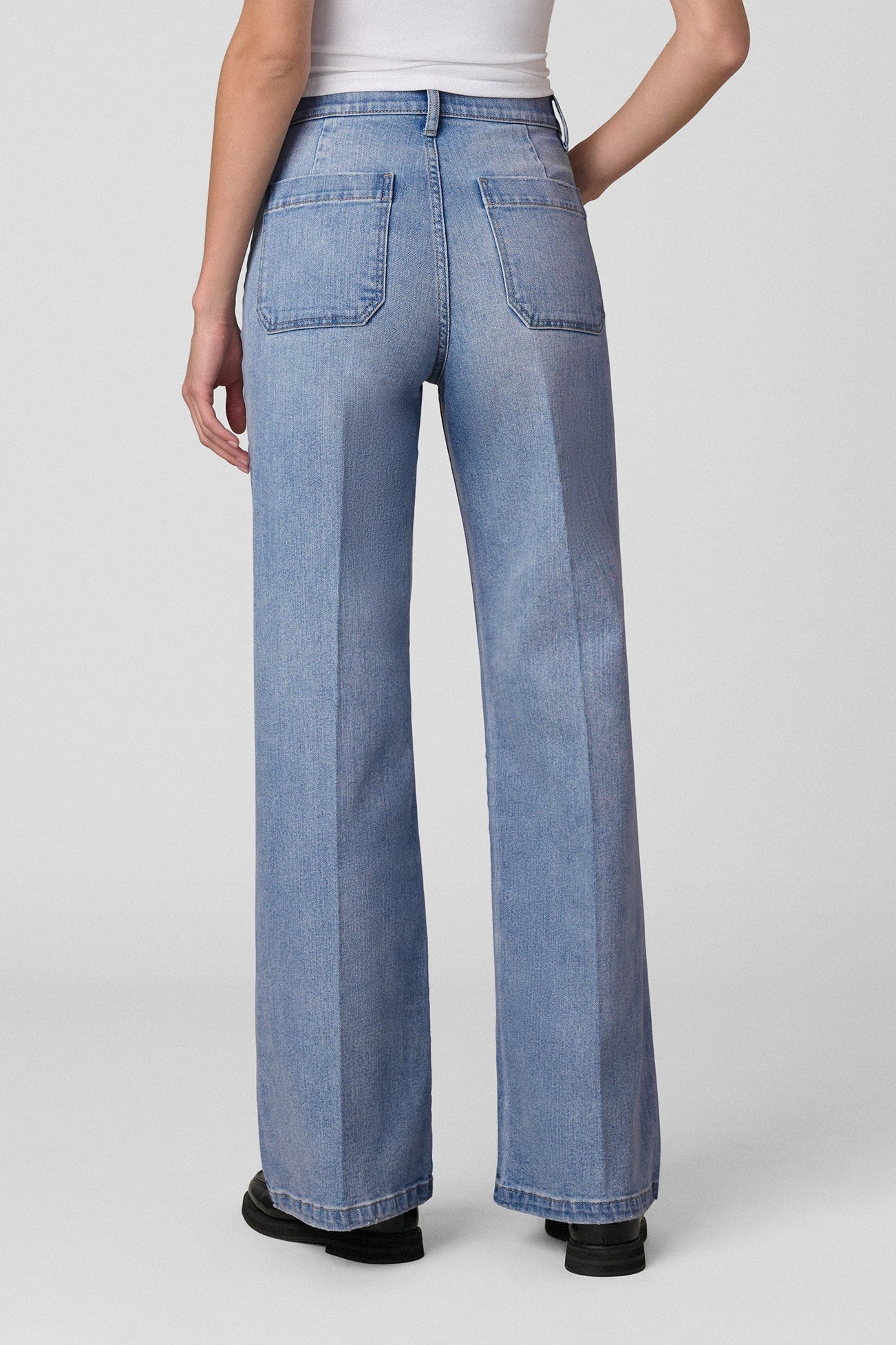 Back view of woman wearing a white t-shirt and Joe's Mia Patch Pocket blue jeans in Amiable color on a white background