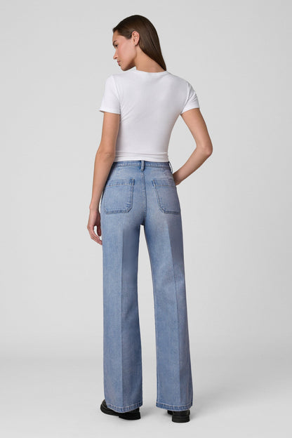 Back view of woman wearing a white t-shirt and Joe's Mia Patch Pocket blue jeans in Amiable color on a white background