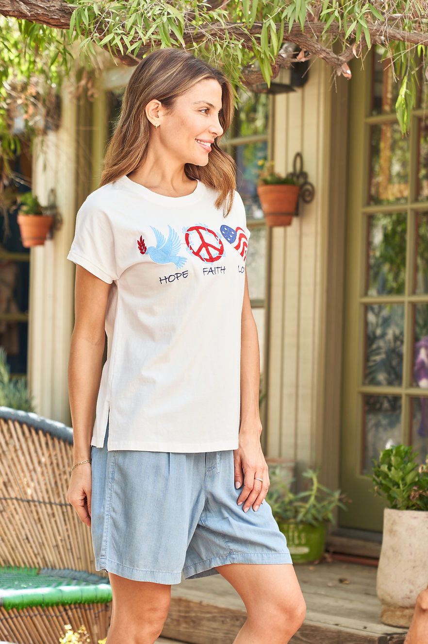 White cap-sleeve jersey tee with front peace graphic, side view