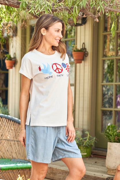 White cap-sleeve jersey tee with front peace graphic, side view