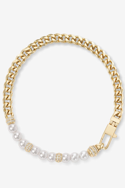 A gold-toned Cuban link chain bracelet with a section of white pearls accented by small gold and crystal details, displayed on a clean white background.