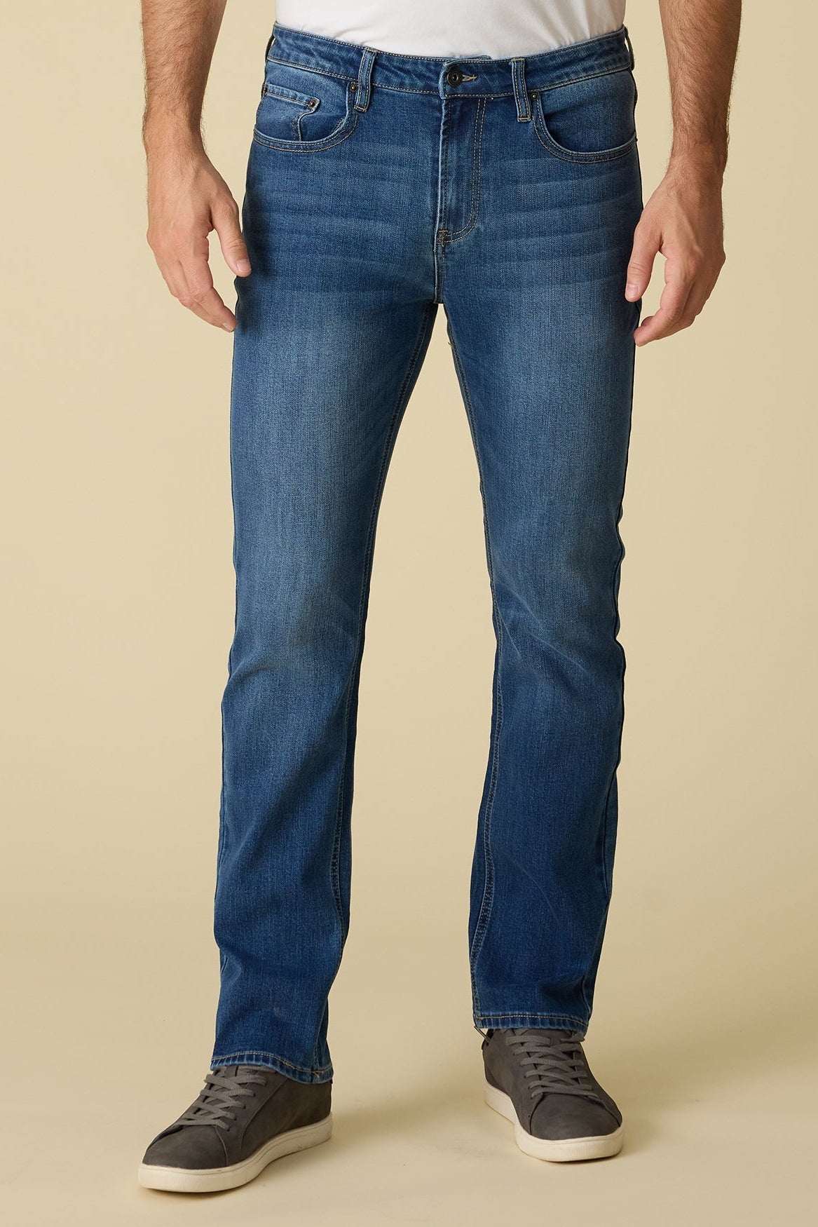 Person wearing highland cooling nashville straight medium wash blue jeans on a beige background