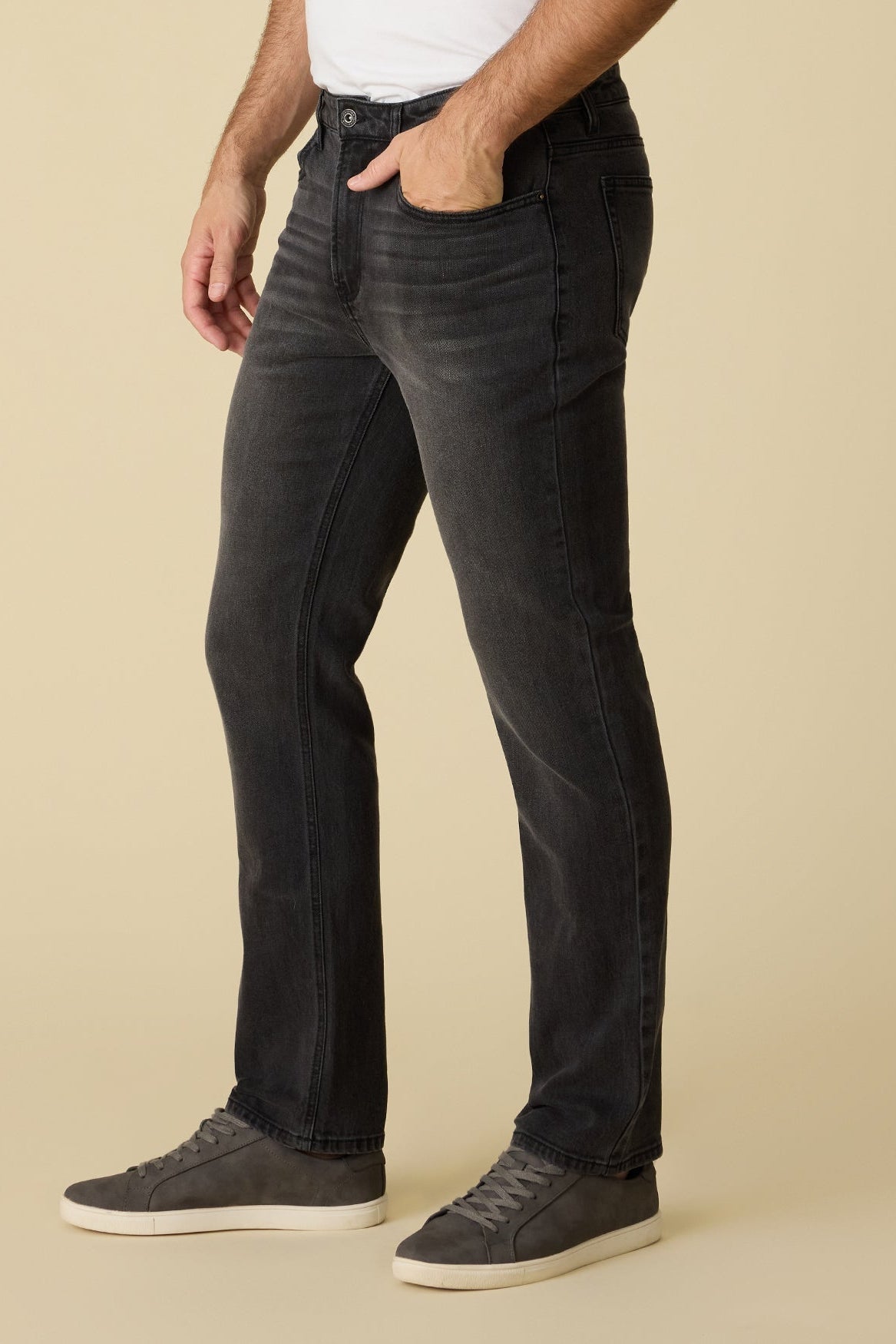 Side view of person wearing black Baytown cooling Nashville Straight jeans and a white shirt on a beige background