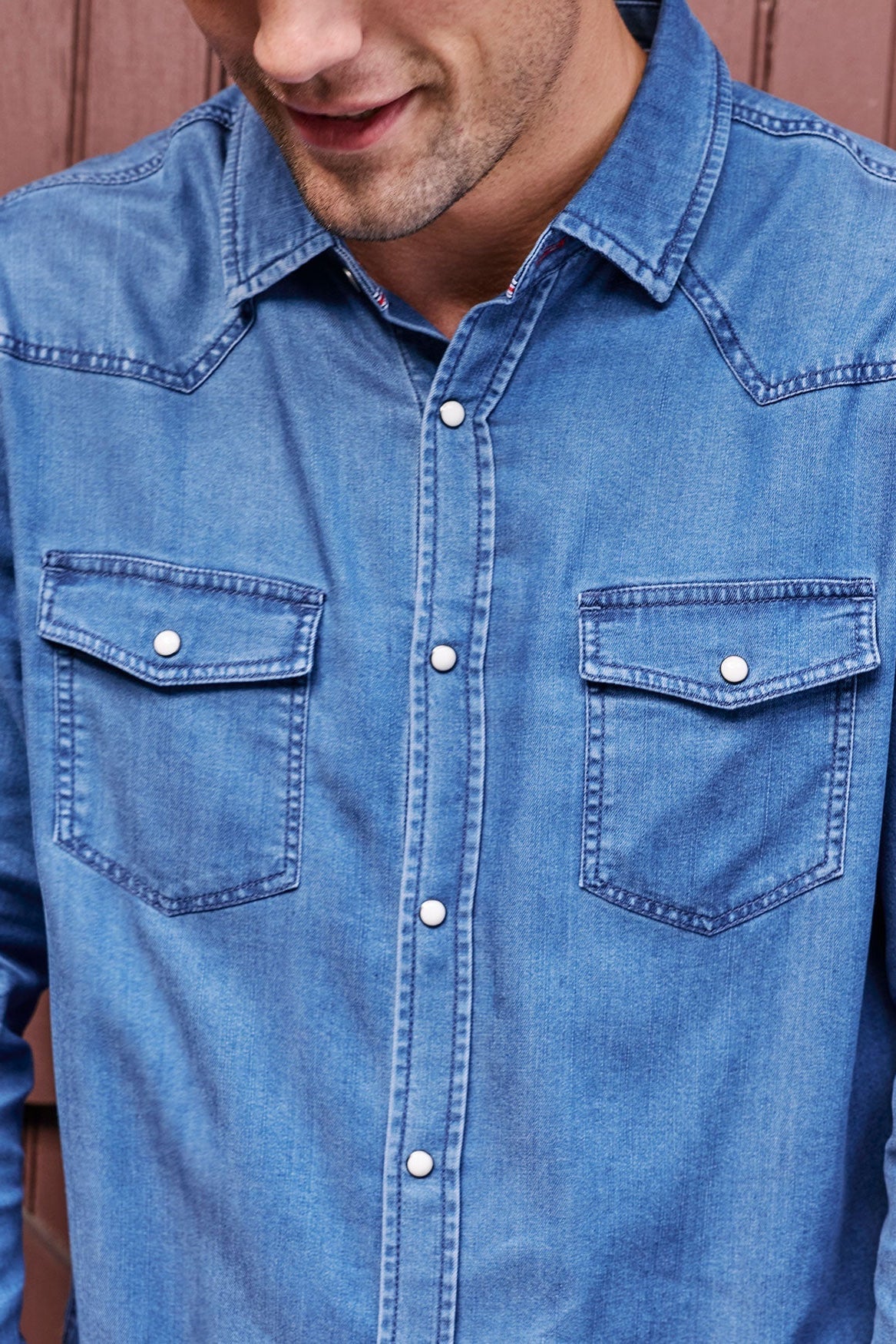 Close up of man wearing Sacramento Longsleeve Chambray Western Shirt in Medium Wash