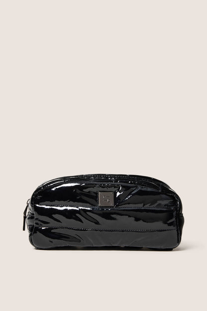 Black patent leather pouch on a beige background