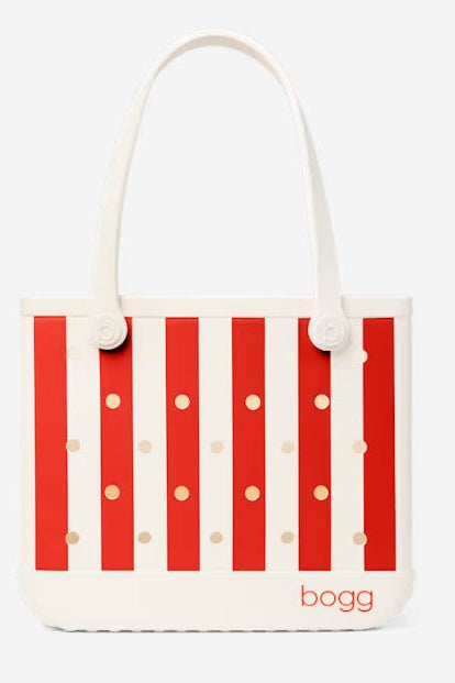 A Bogg brand tote bag featuring a red and white vertical stripe pattern with small gold polka dots, white shoulder straps, and the 'bogg' logo printed in red on the bottom right.