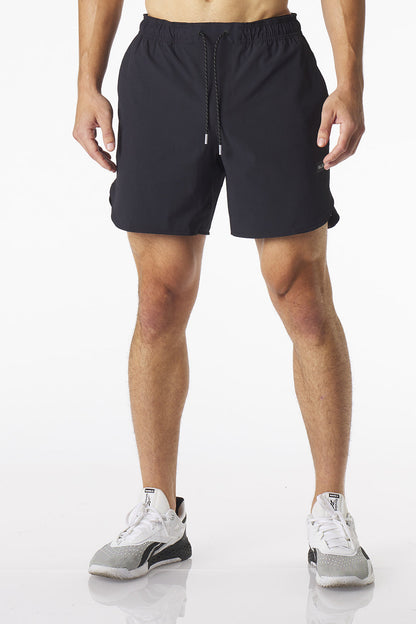 A man wearing black Luka HD athletic shorts and white and gray running shoes, shown from the waist down against a clean white studio background.
