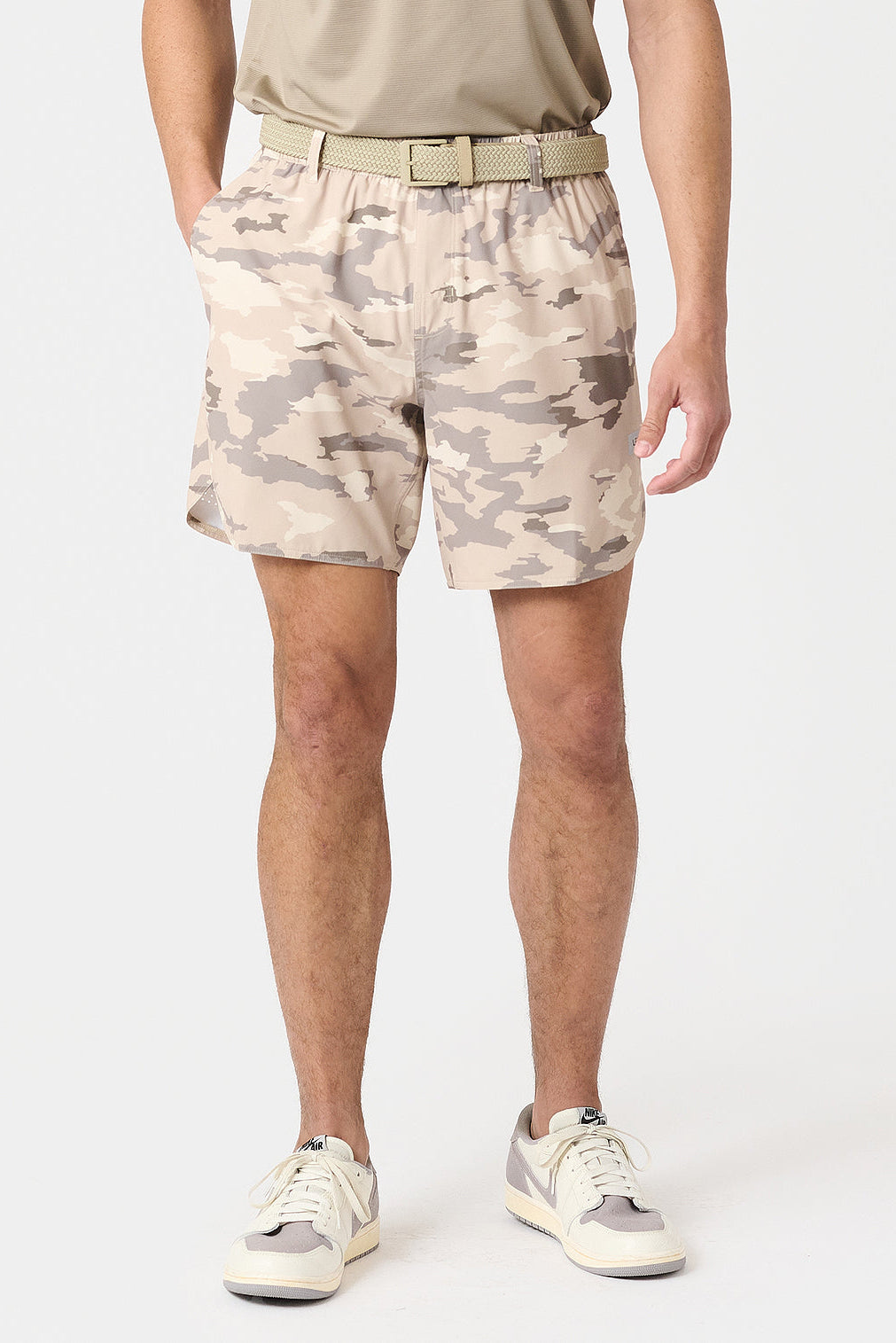 Person wearing river rock camouflage Luka golf shorts on a white background