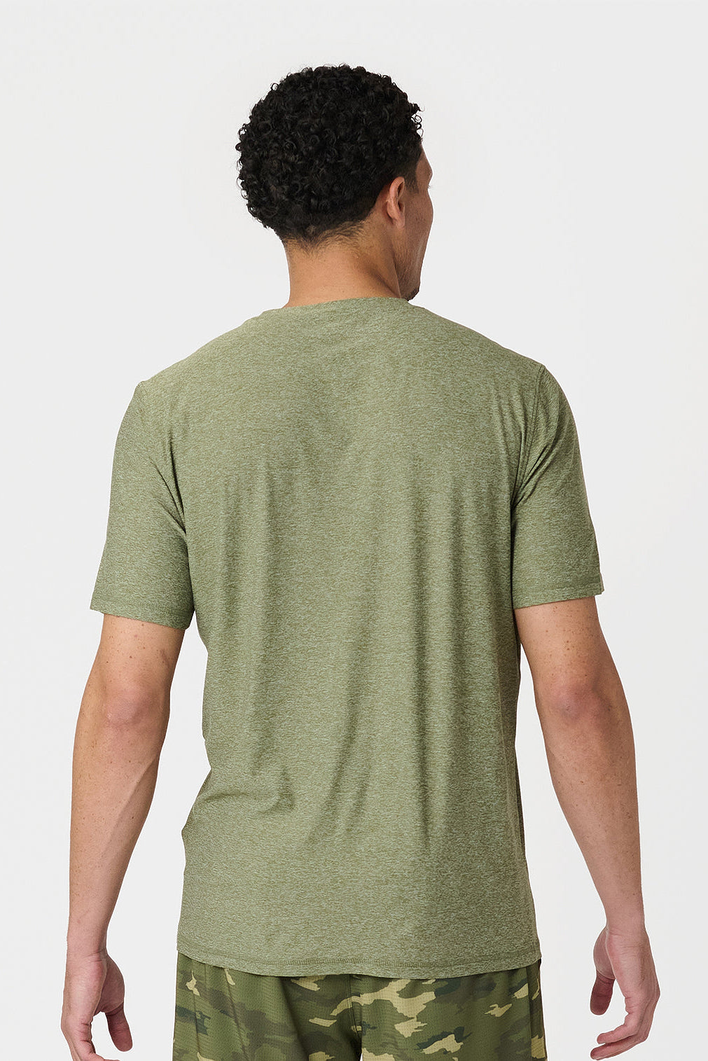 Person wearing a cypress heather green t-shirt and camouflage shorts on a white background