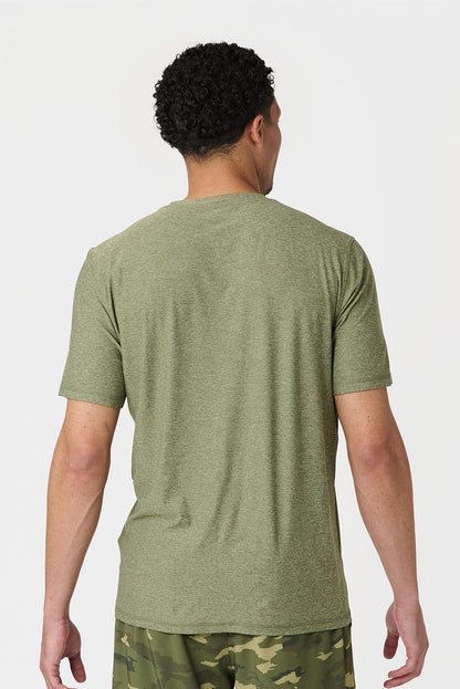 Person wearing a cypress heather green t-shirt and camouflage shorts on a white background