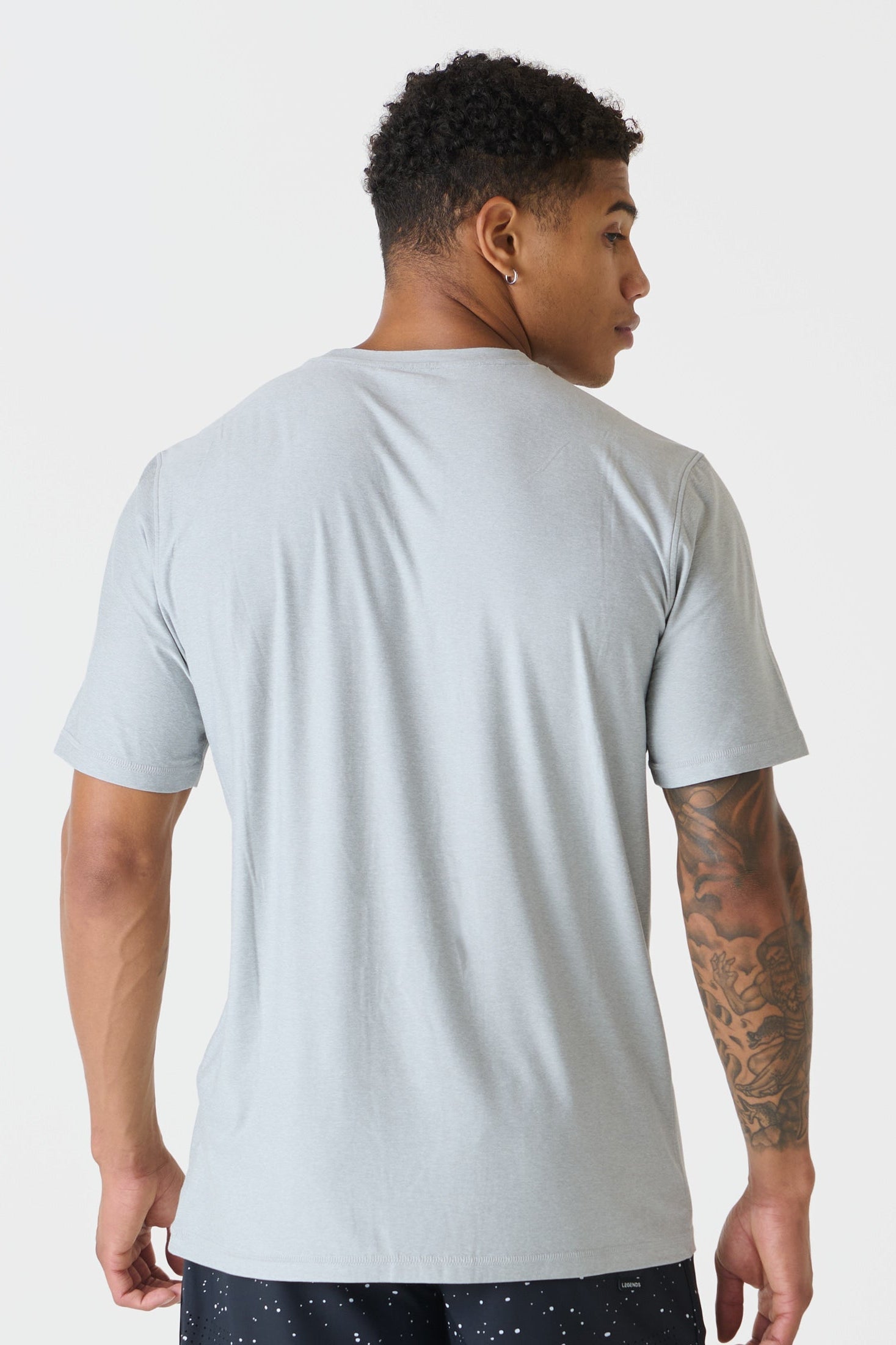A man shown from the back wearing a heather gray crewneck t-shirt, photographed against a clean white studio background.
