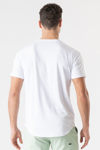 A man viewed from behind wearing a plain white short-sleeve t-shirt and light green shorts against a clean white studio background.