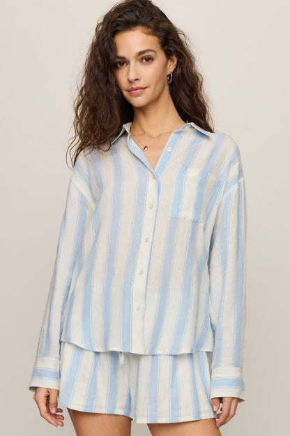 Woman wearing a skyline light blue and white striped shirt on a beige background