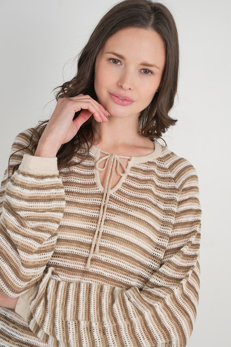 Woman wearing a striped sweater against a plain background