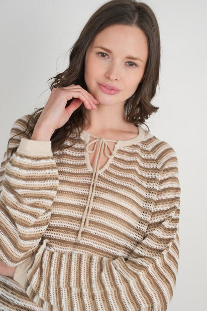 Woman wearing a striped sweater against a plain background