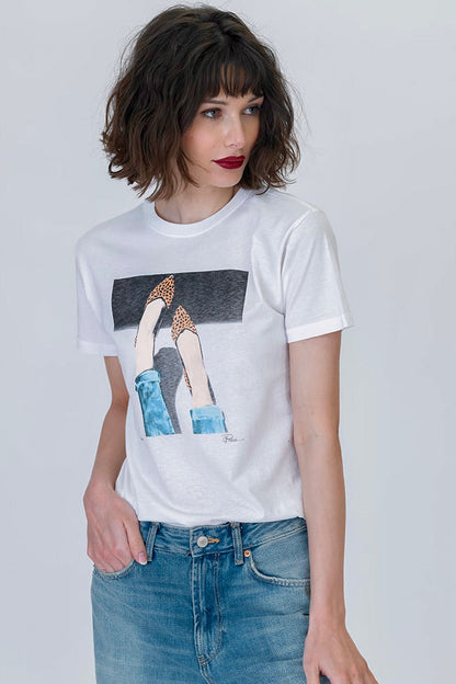 Woman wearing the 5th Ave mushie tee featuring legs and feet wearing leopard flats in white with blue jeans 