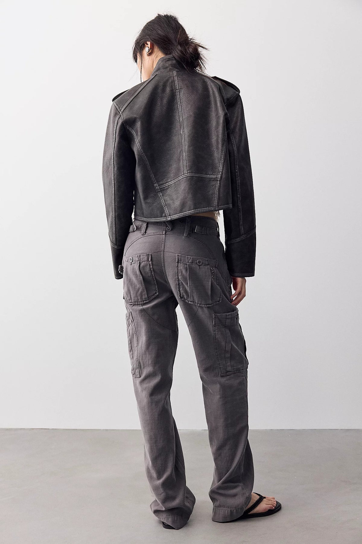 Woman shown from the back wearing a washed black jacket and Tight fuse slim utility pant in charcoal grey 