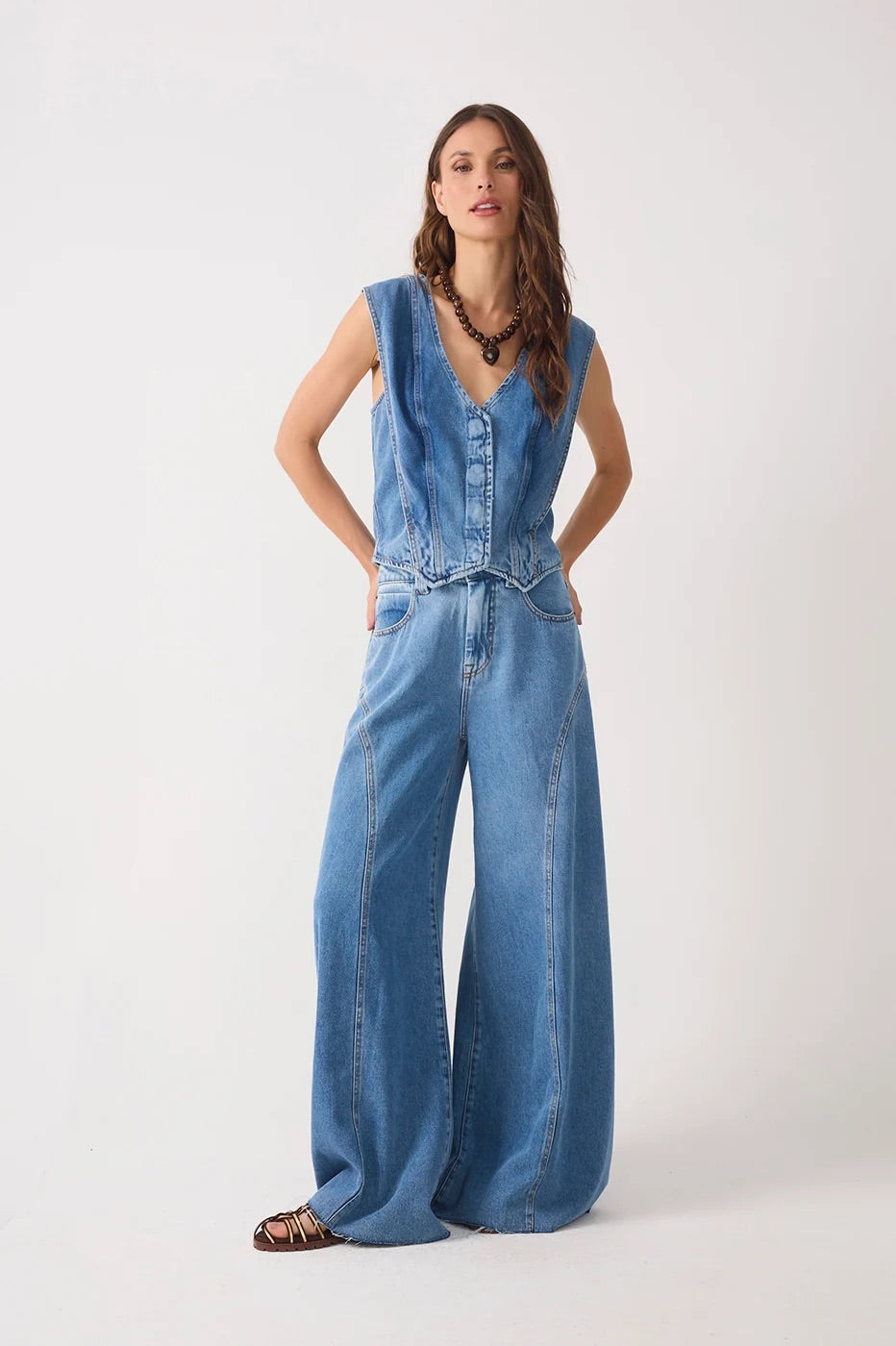 Woman wearing a denim top and denim pockets belt loops flared pants from the front