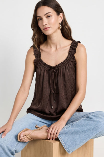 Woman wearing a satin Ruffle Trim Tie Neck Tank in chocolate brown color 