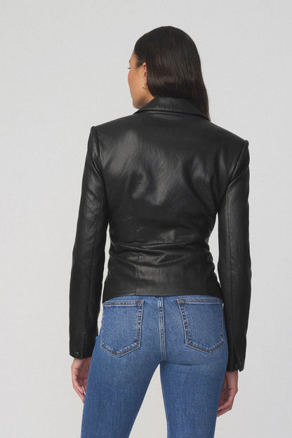 Back view of woman wearing black fitted blazer and blue jeans 