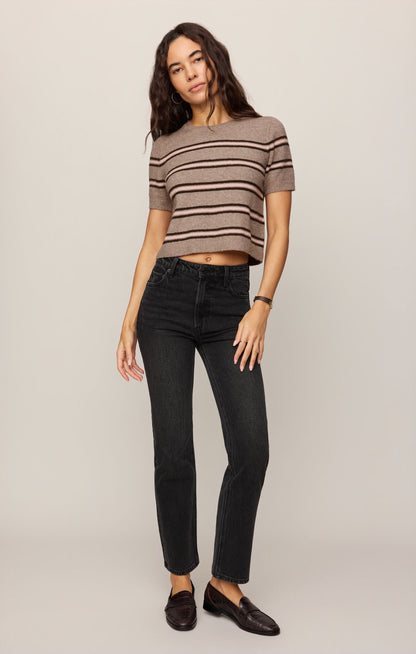 Woman wearing a Gatewood striped sweater in Heather Ash color and black jeans against a plain background