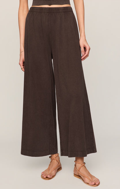Front view of woman wearing dark chocolate "Scout" crop flare pants on a plain background