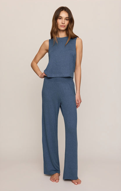 Woman wearing a true navy sleeveless top and matching pants on a beige background