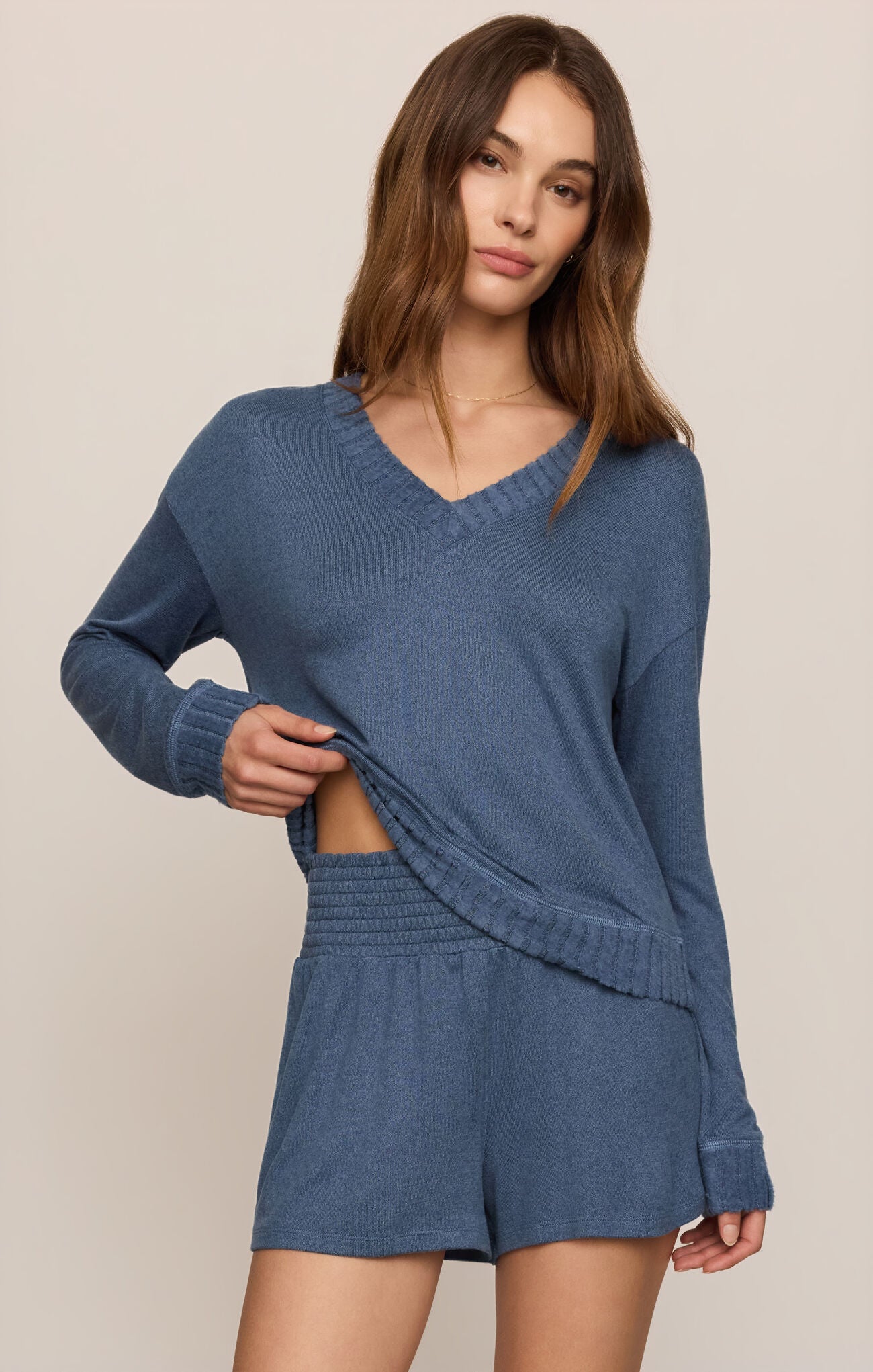 Woman wearing a Courtney Long Sleeve vneck top in True Navy and matching shorts on a beige background
