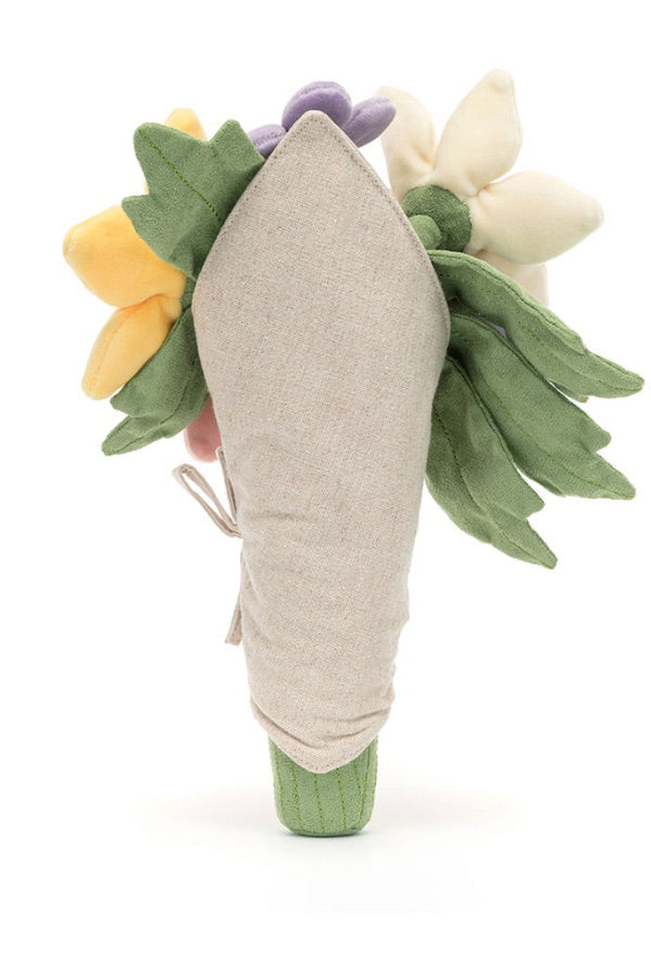 A fabric flower bouquet accessory, featuring a beige fabric stem wrapped with a small ribbon, decorated with green felt leaves, yellow and white felt flowers, and a purple felt accent, set against a plain white background. Amuseables bouquet of flowers back view
