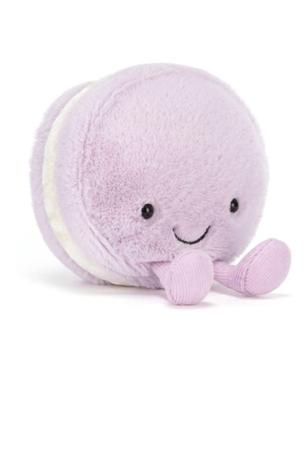 A cute, round plush May macaron toy in light lavender purple with cream-colored filling and small pink feet, shown on a clean white background.