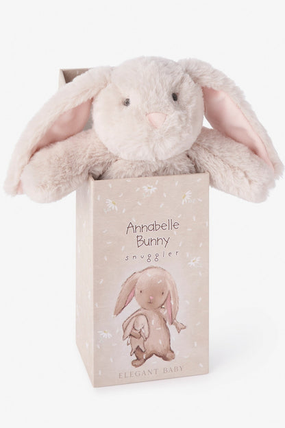 A plush bunny toy snuggle plush with long floppy ears sits inside a decorative gift box. The bunny is a very light warm gray-beige with pale pink inner ears.