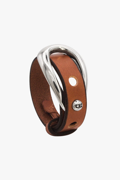 A brown leather ring with a polished silver-toned twisted metal band, featuring a small silver 'CXC' logo on the side, set against a plain light gray background.