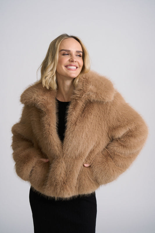 Woman wearing a black dress & a Dark sand sienna fur jacket 