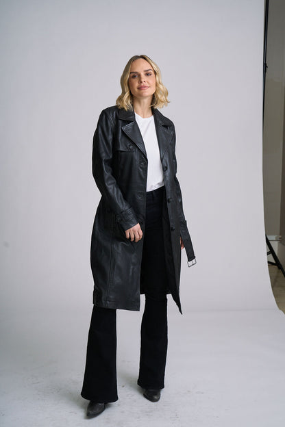 Woman wearing a white tee and black pants with a black Leah trench coat style black leather Jacket 
