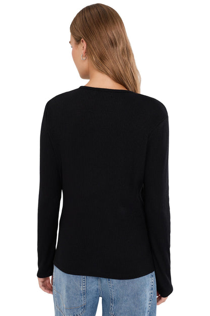 A woman viewed from the back wearing a black long-sleeve ribbed knit top and light blue jeans against a plain white background.