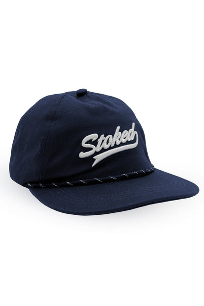 A navy blue baseball cap with 'Stoked' embroidered in white script on the front, featuring a braided rope detail around the edge of the brim, set against a plain white background.