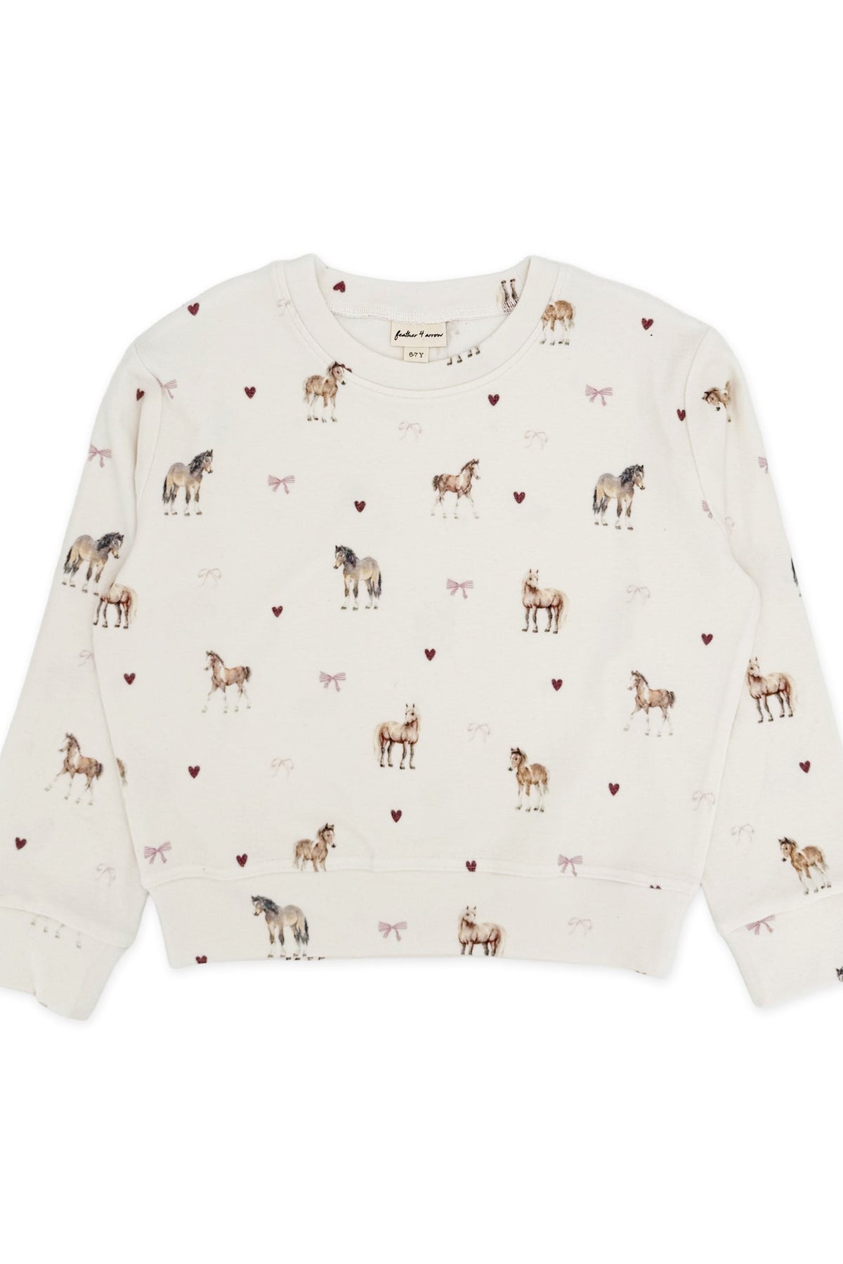 An off-white long-sleeve crewneck sweatshirt featuring an all-over print of horses, pink bows and small pink hearts, laid flat against a white background.