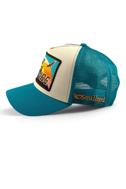 A teal and cream trucker hat with a curved brim, featuring a colorful 'Paradise' patch on the front and a gold 'Soulhyd' logo on the side mesh.