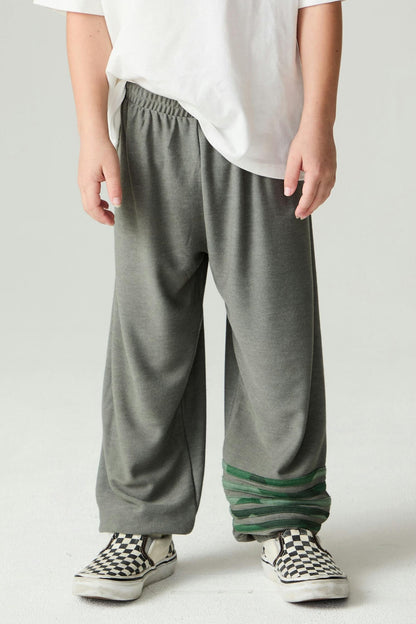 Person wearing safari green jogger style pants with green camo stripe accents on a plain background