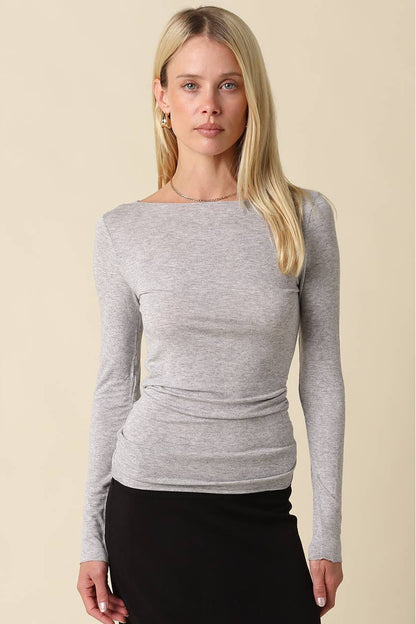Woman wearing a heather grey long sleeve shirt with black pants 