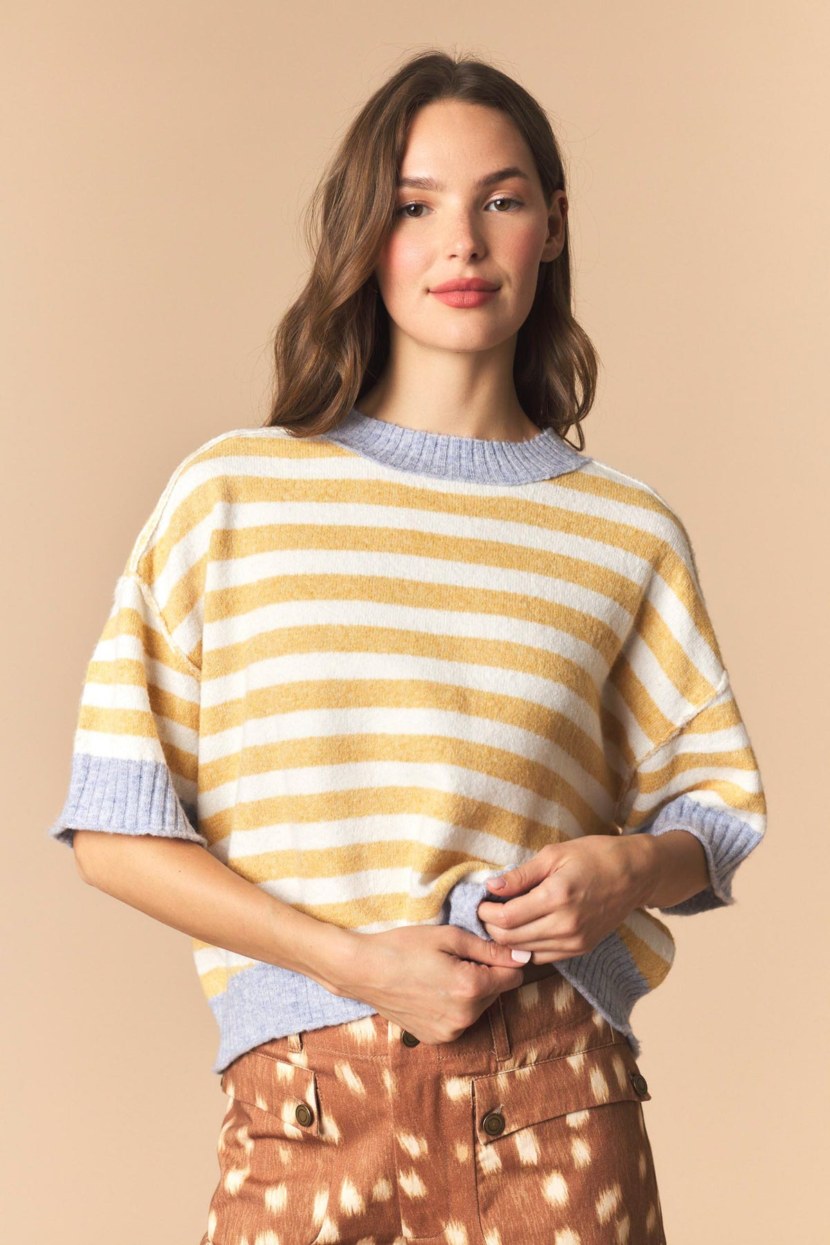 Woman wearing a Rib Stripe Short Sleeve Crop Sweater in dark yellow and dusty blue with stripes 
