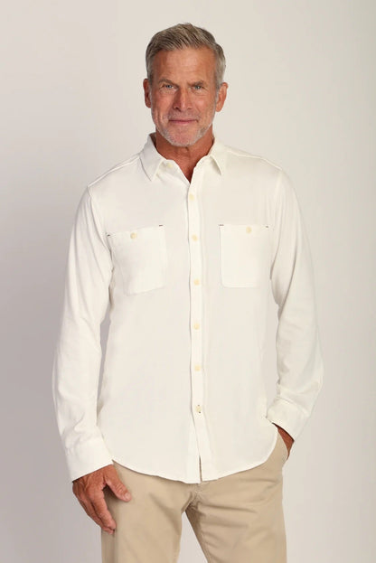 Man wearing long sleeve button down shirt with double pockets in vintage chalk color with khaki pants 