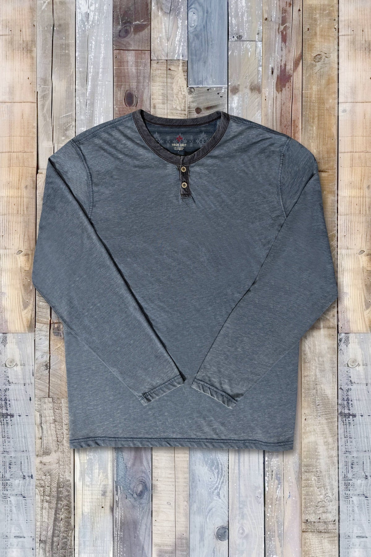 A carbon gray long-sleeve slit tee shirt with a dark ribbed collar and two button placket, laid flat on a rustic wood plank background.